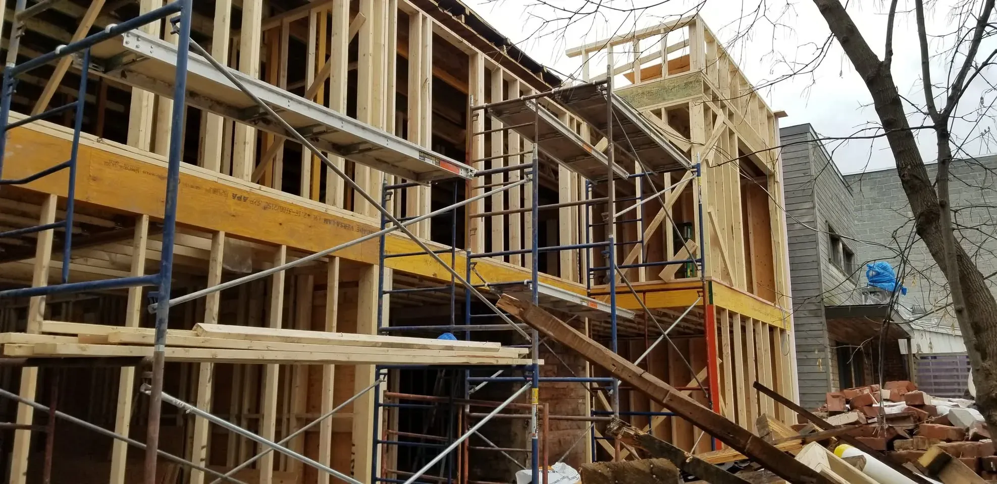 Ossature de bois d'un agrandissement de deux étages, échafaudage monté sur toute la hauteur de la façade
