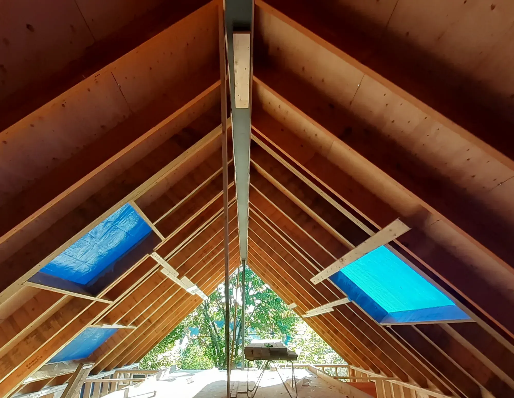 Intérieur d'un comble neuf, chevrons et entretoises en place, panneaux d'isolant rigide posés entre les chevrons