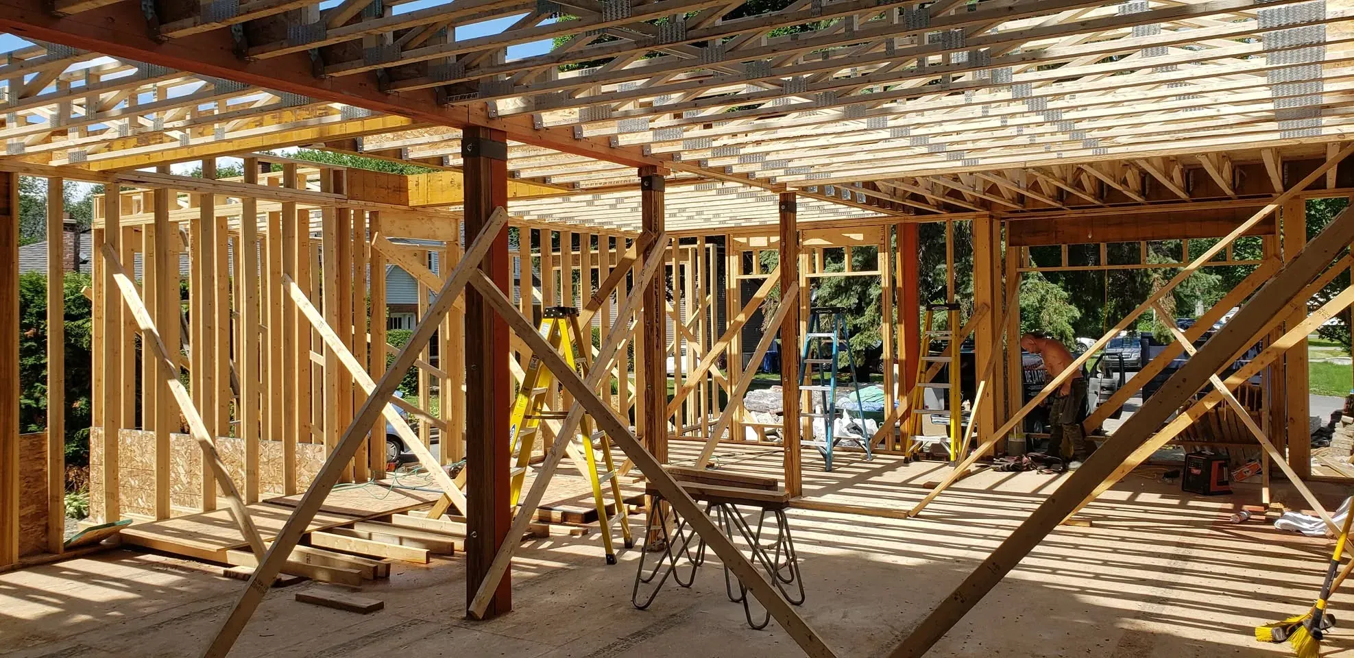 Intérieur d'une construction neuve : solivage du plancher de l'étage porté par des poteaux d'acier, ossature ouverte