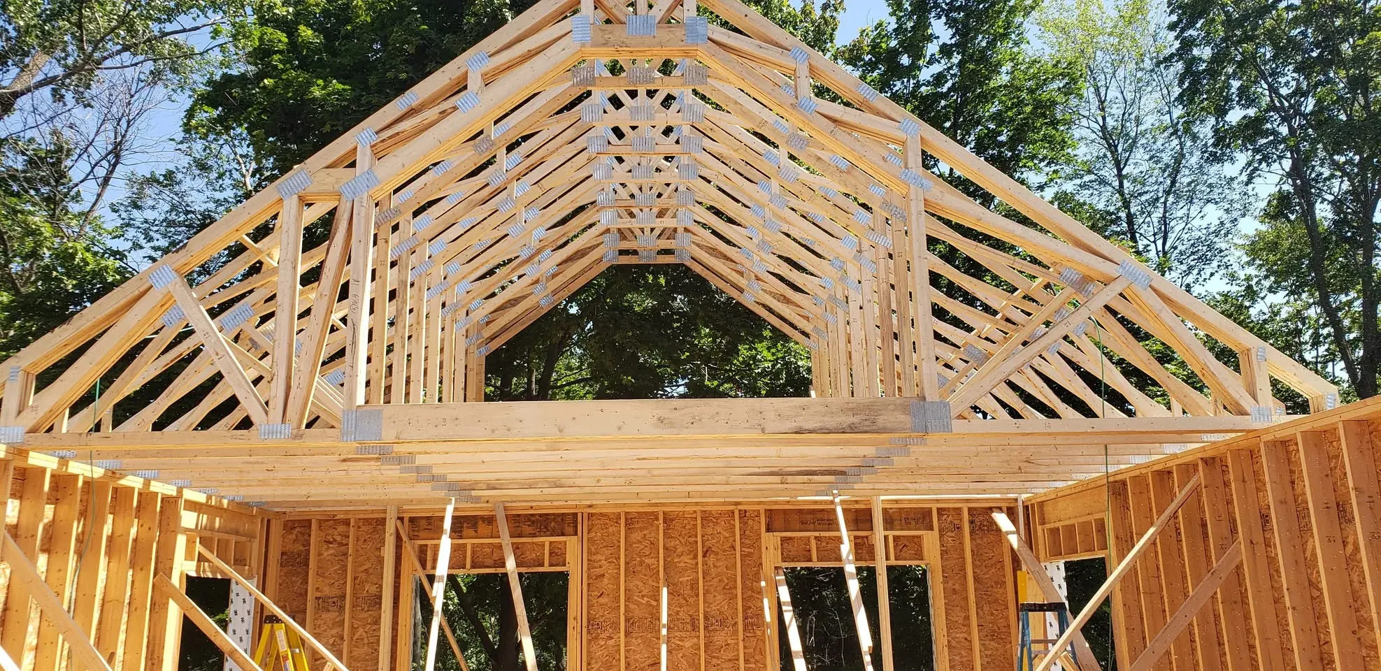 Pignon d'une maison neuve, fermes de toit à comble habitable et ossature de murs en panneaux
