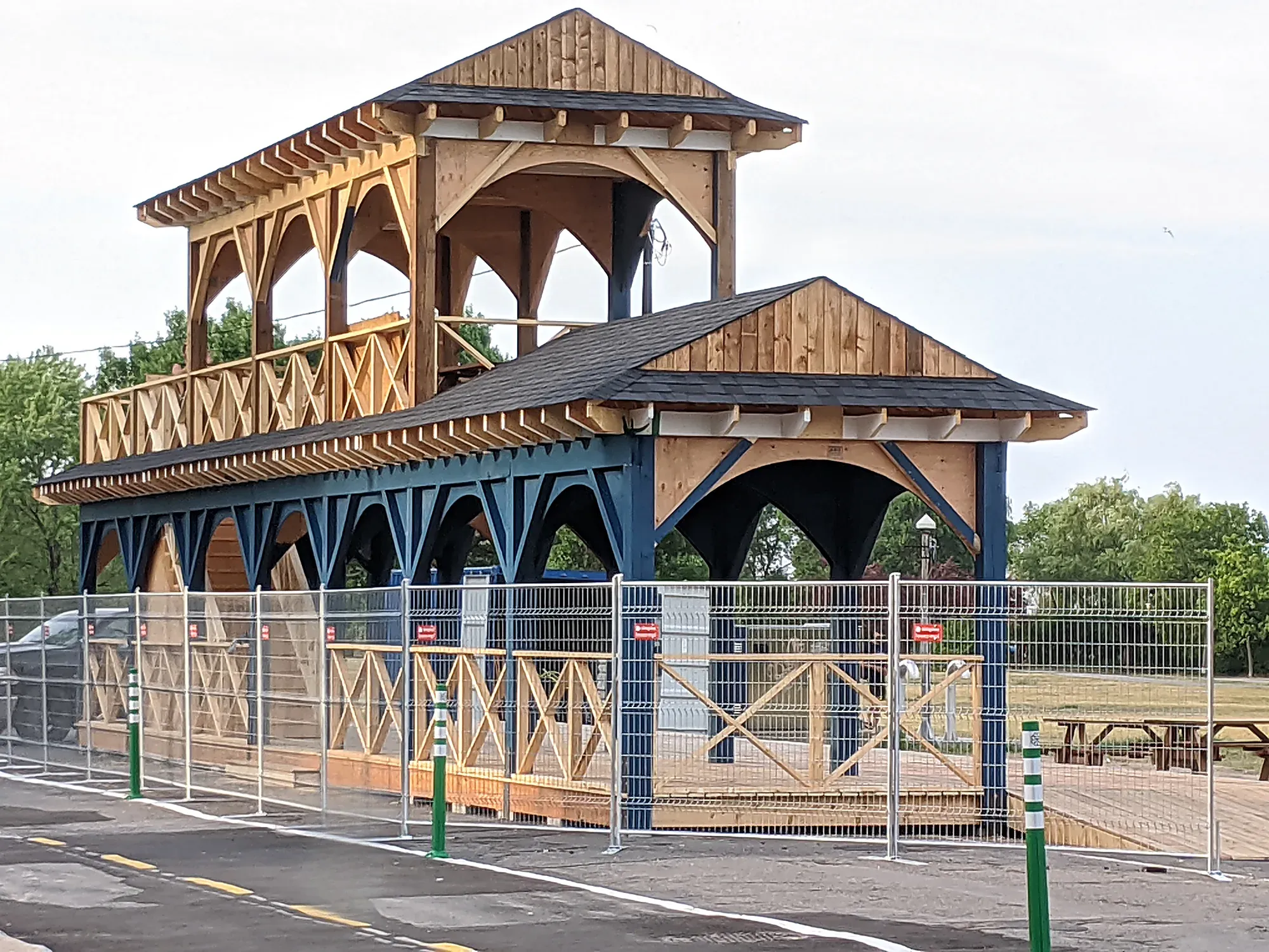 Halle publique de bois à deux niveaux terminée, belvédère couvert à l'étage, colonnes et aisseliers peints