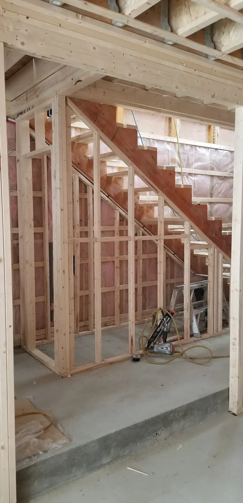 Cage d'escalier neuve en ossature de bois, montée sous un escalier existant dans un sous-sol