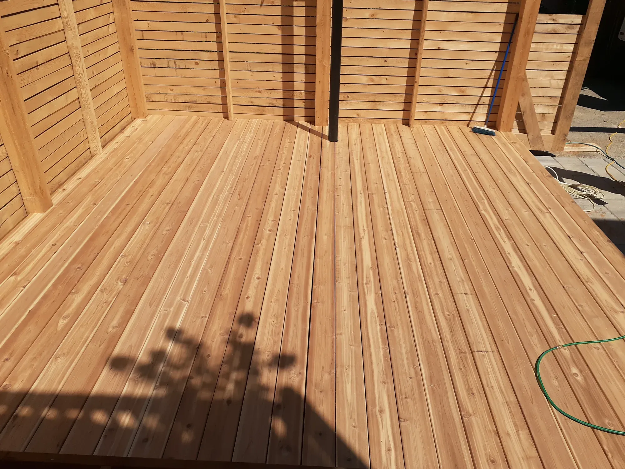 Plancher de terrasse en cèdre neuf, entouré d'un écran d'intimité à claire-voie en bois